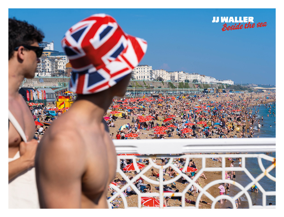 Busy beach with a person on the pier