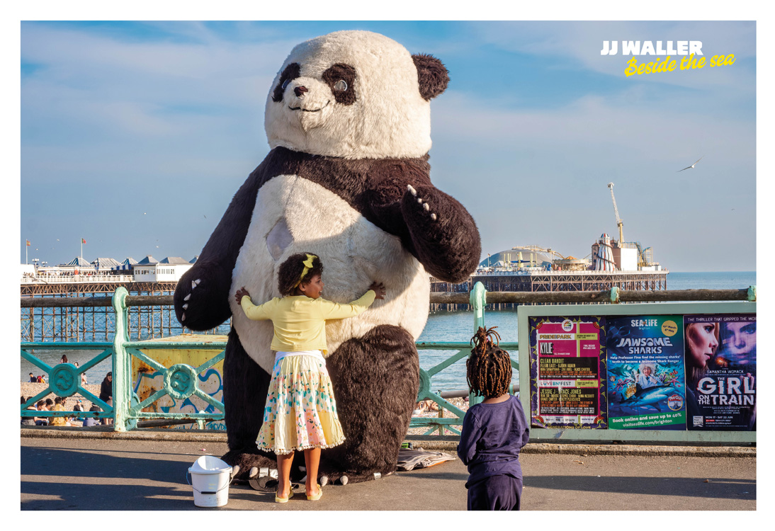A child hugging a giant panda mascot