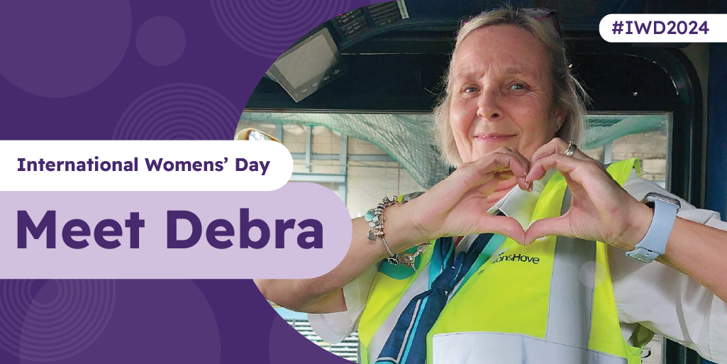 A bus driver sat in the driver's seat making a heart gesture with their hands with text saying 'Meet Debra'