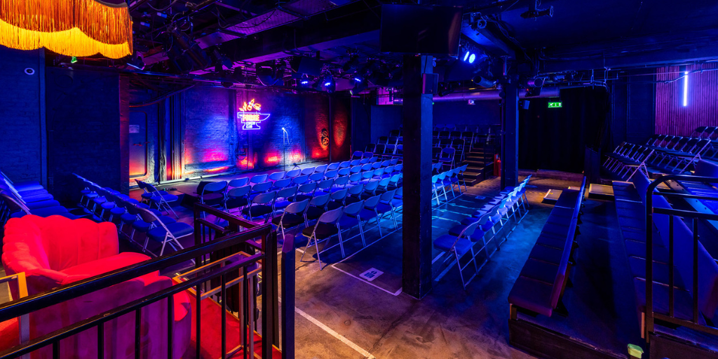 event space with seating and a stage and low level lighting