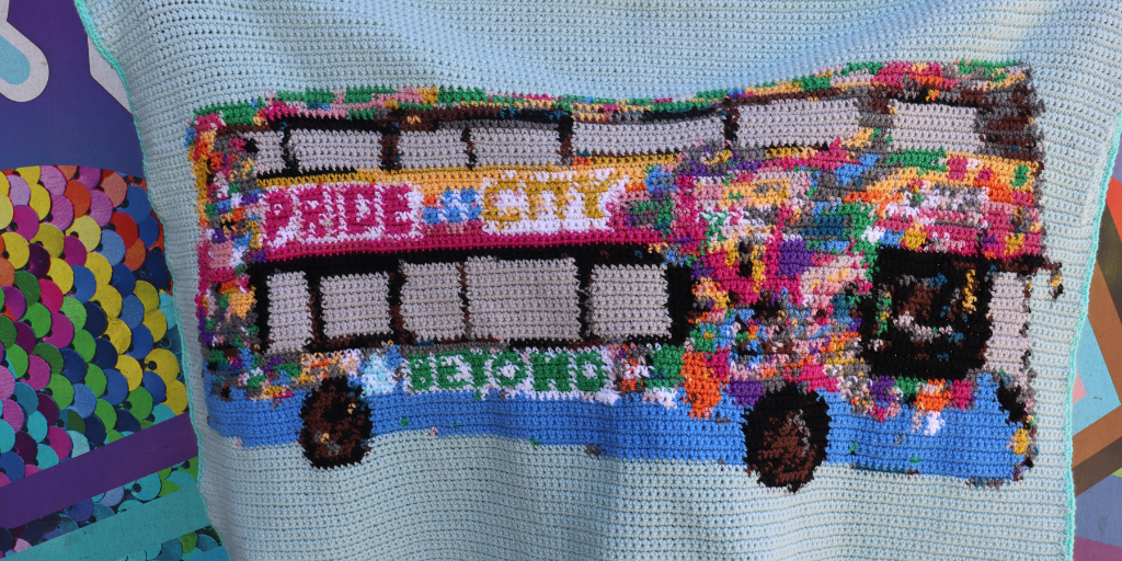 crochet blanket featuring the pride bus