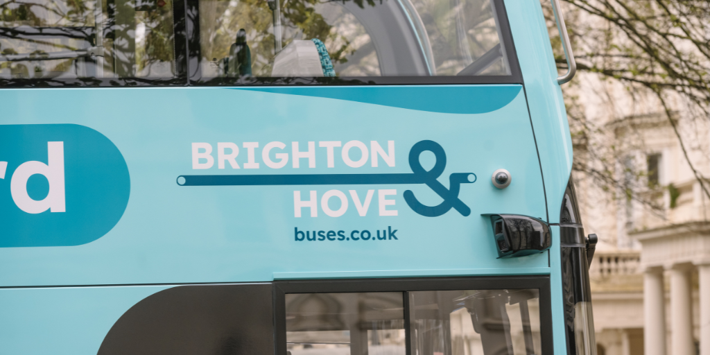 Close up image of teal Brighton & Hove bus displaying company logo
